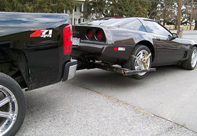 black-pickup-towing-corvette-tow-dolly